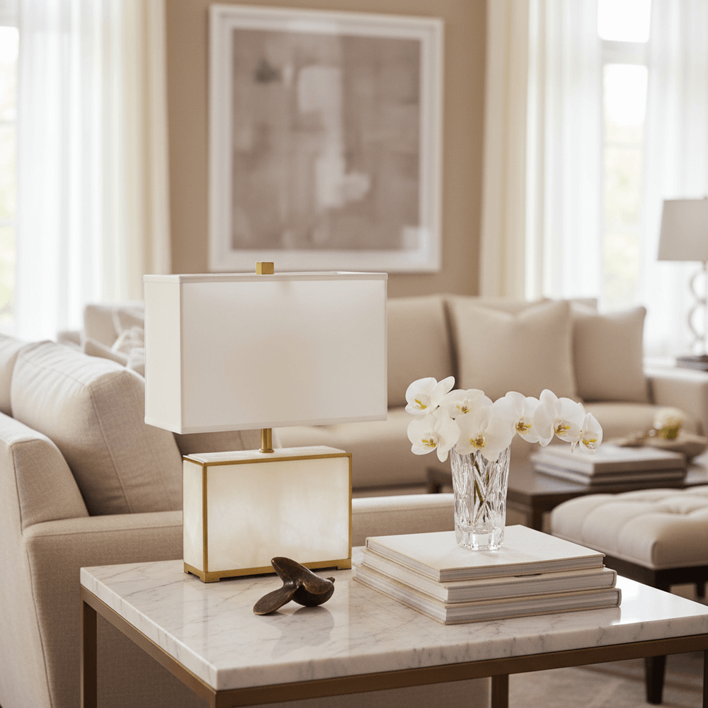 Table lamp in a living room with beige sofa, marble coffee table, and decorative items.