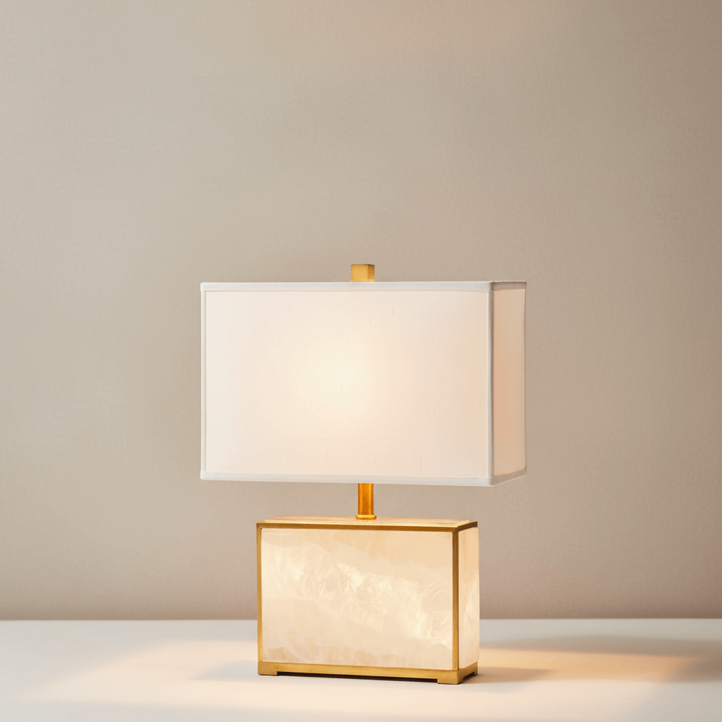Table lamp with gold base and white shade on a neutral background