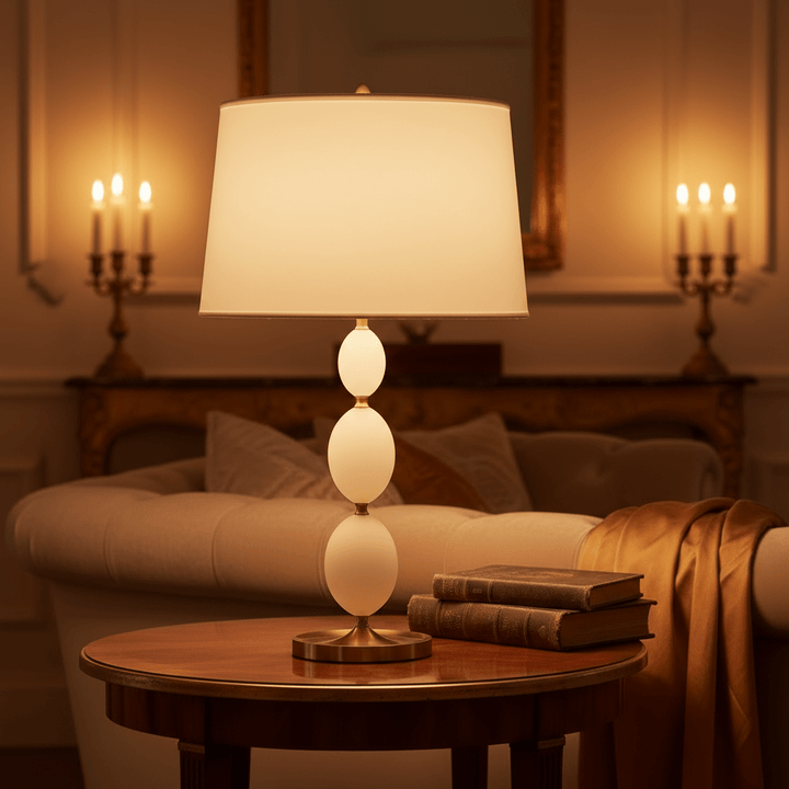 Decorative lamp on a table with candles and a couch in the background