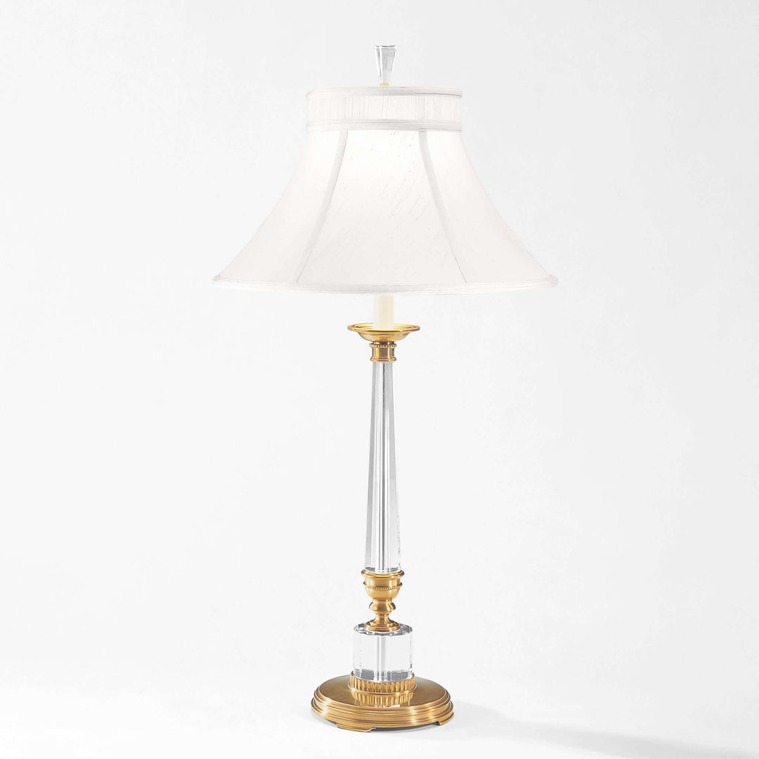 Decorative table lamp with gold base and clear glass on a white background