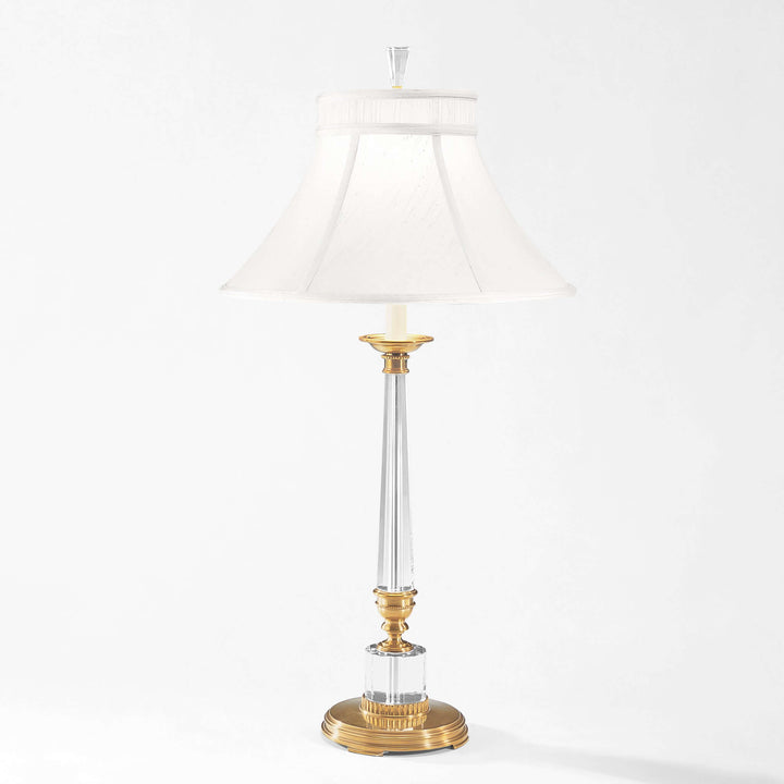 Decorative table lamp with gold base and clear glass on a white background