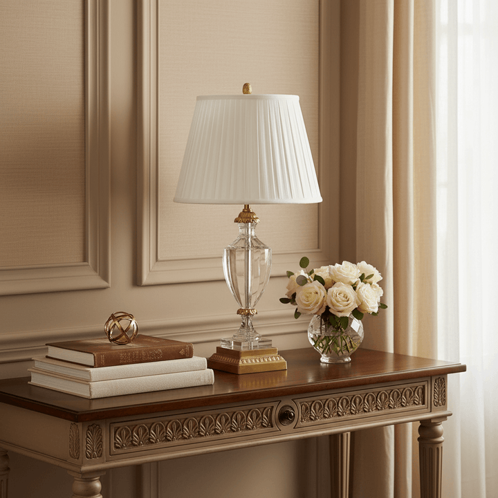 Decorative table with lamp, books, and flowers in a room with beige walls and curtains.