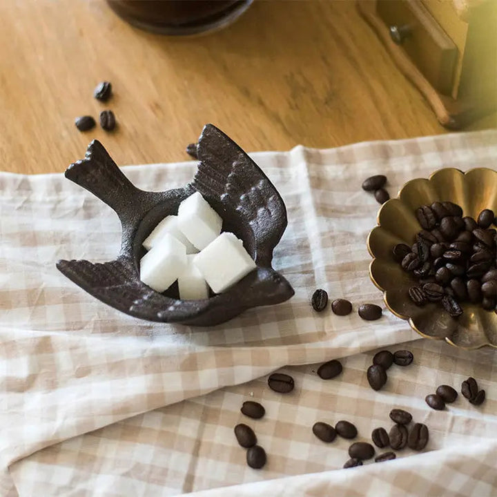 Cast iron bird holder styled with sugar cubes on checked linen
