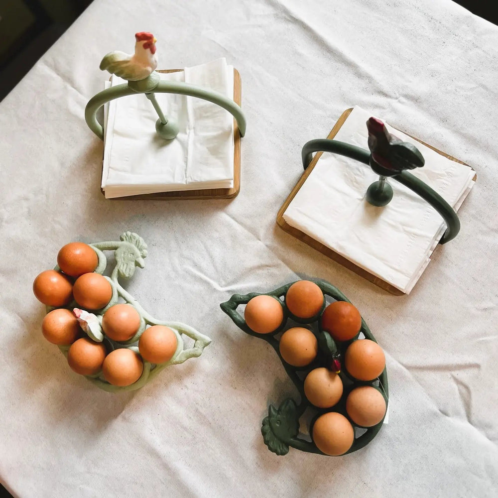 Two green egg racks with eggs beside separate napkin holders