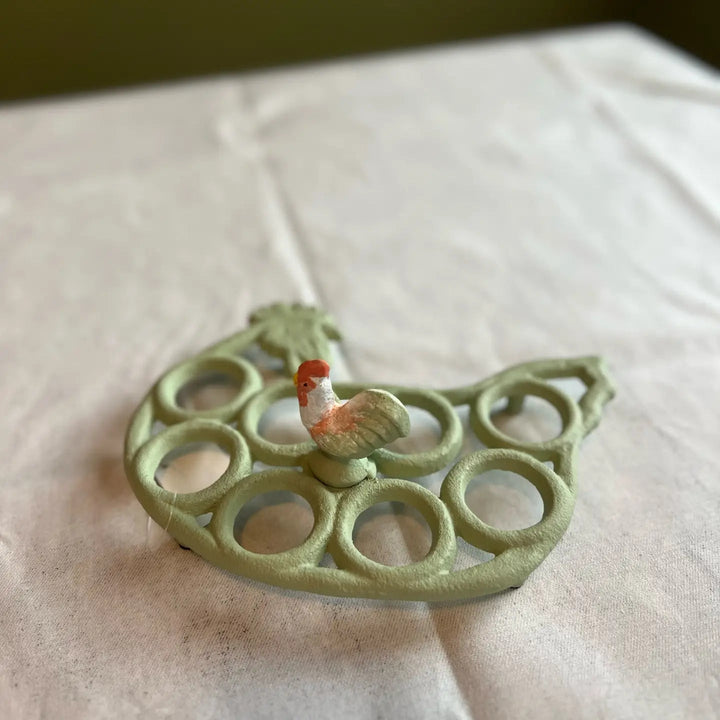 Empty light green egg rack with eight egg positions and a rooster ornament