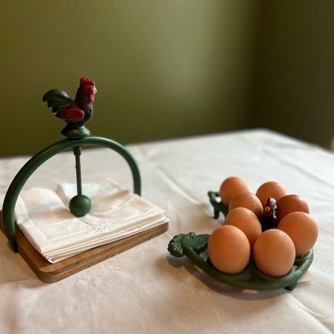 Dark green egg rack with eggs beside a separate napkin holder