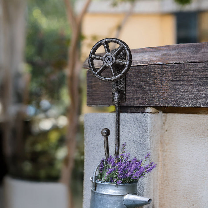 Cast Iron Valve Wheel Wall Hook holding a small garden pail