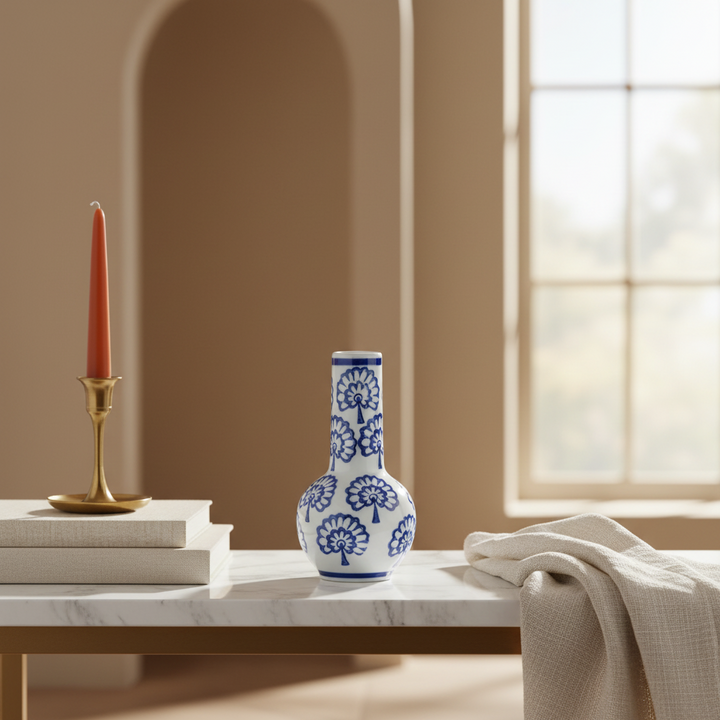 Chinoiserie Blue and White Porcelain Bud Vase on a marble table with candle holder and books.