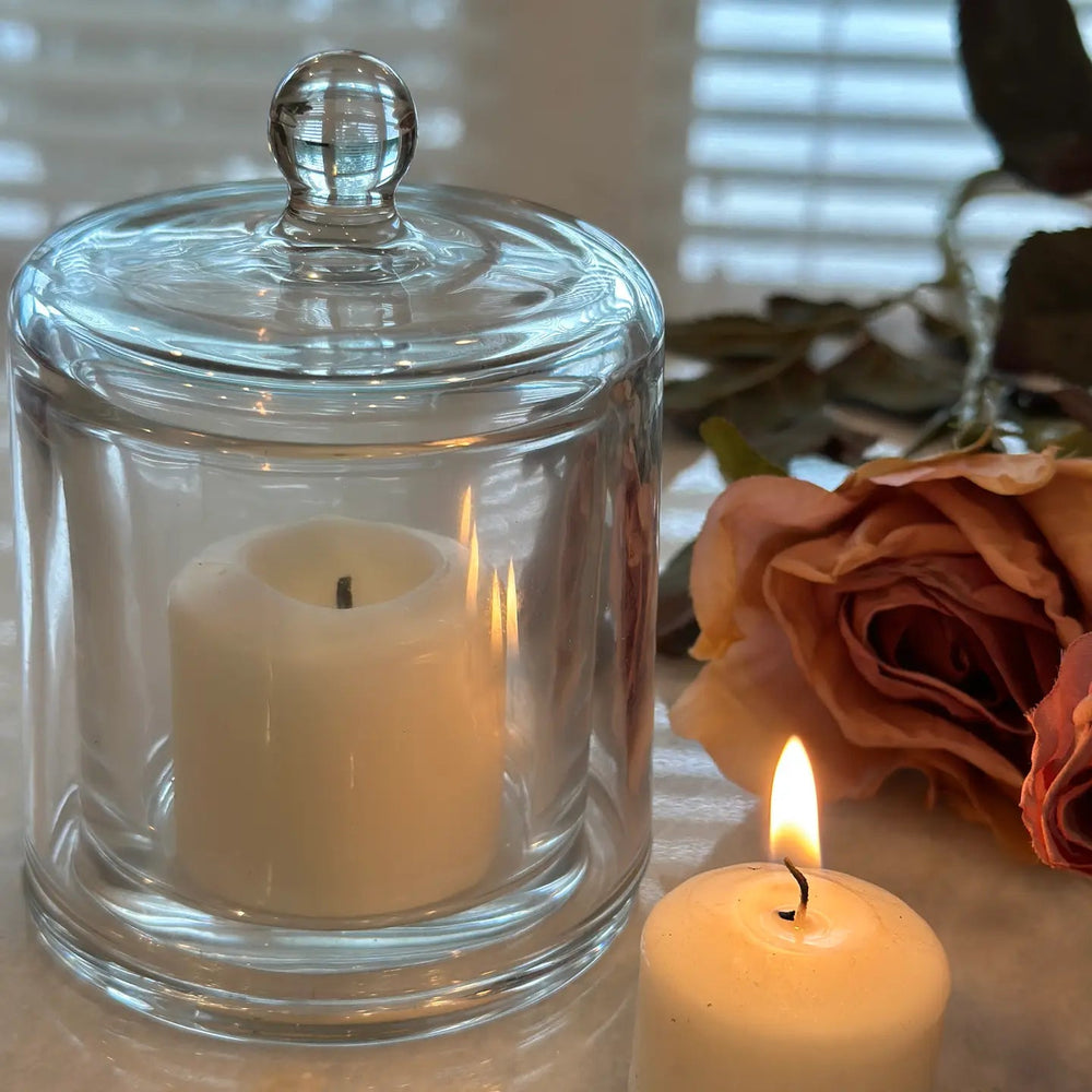 Large glass cloche surrounding a softly glowing candle