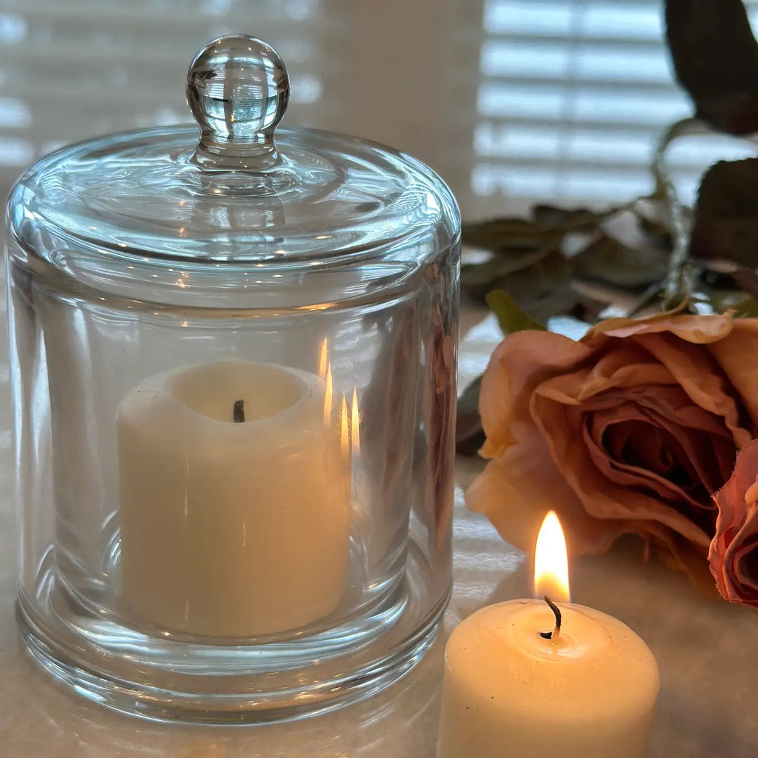 Large glass cloche surrounding a softly glowing candle