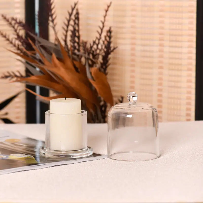 Clear cloche candle holder styled on a warm tabletop