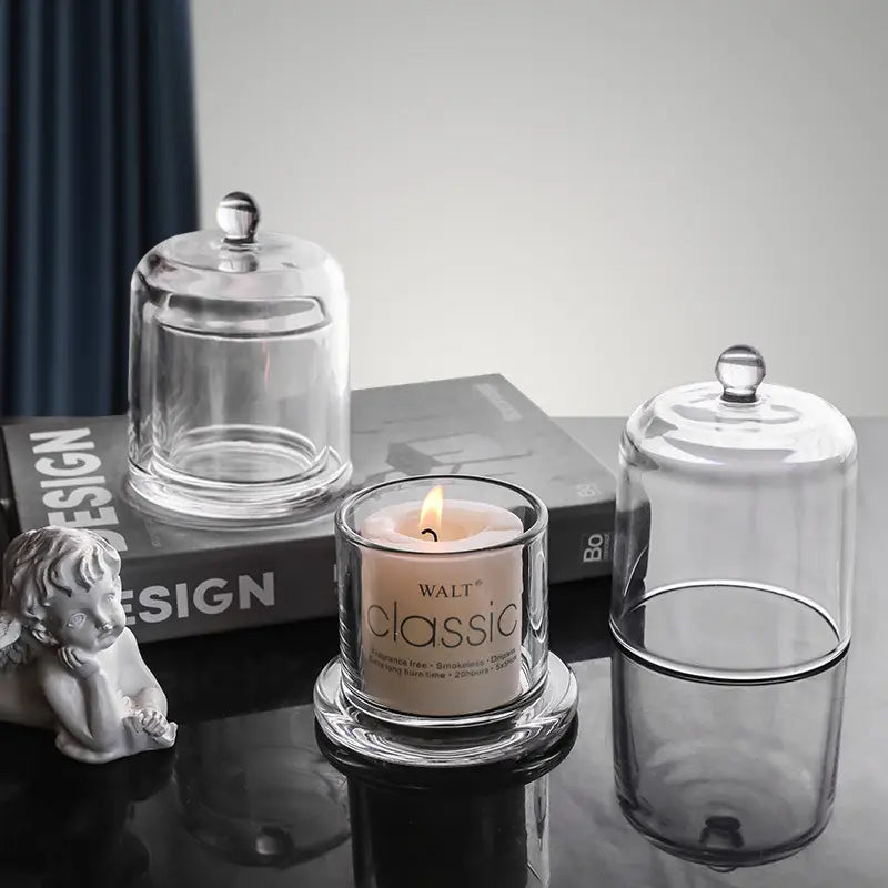 Small and large glass cloche candle holders grouped on books