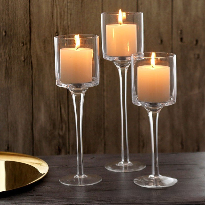 Clear Glass Pedestal Candle Holders, Set of 3 arranged with glowing pillar candles