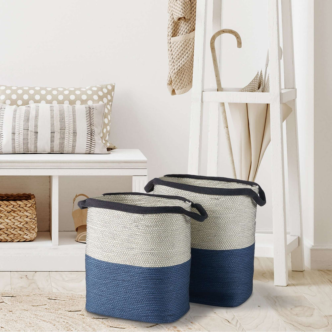 Set of 2 coastal blue and natural woven storage baskets with handles on a light wooden floor.