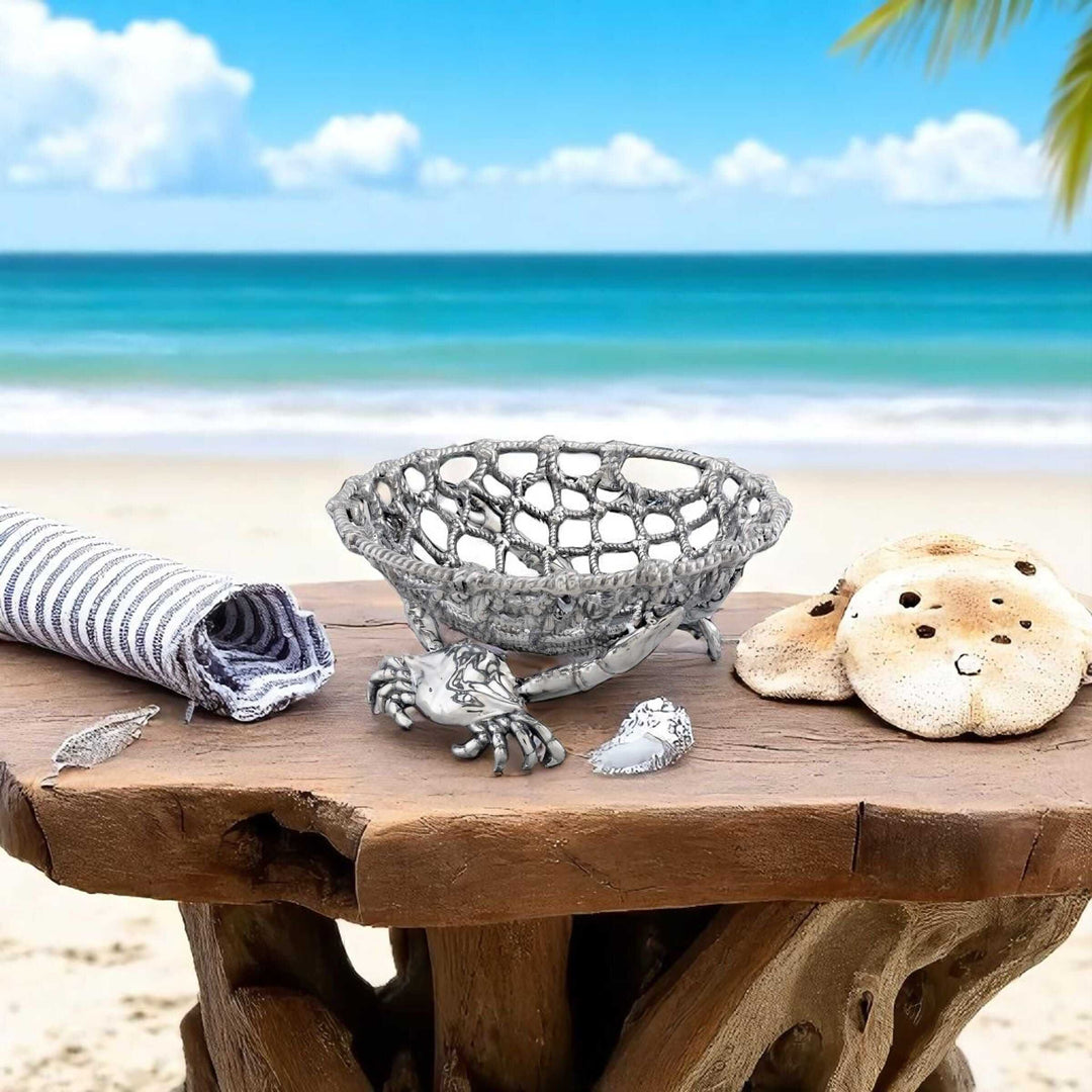 Coastal Crab and Net Fruit Basket on wooden table by the beach, featuring maritime-inspired design and aluminum craftsmanship.