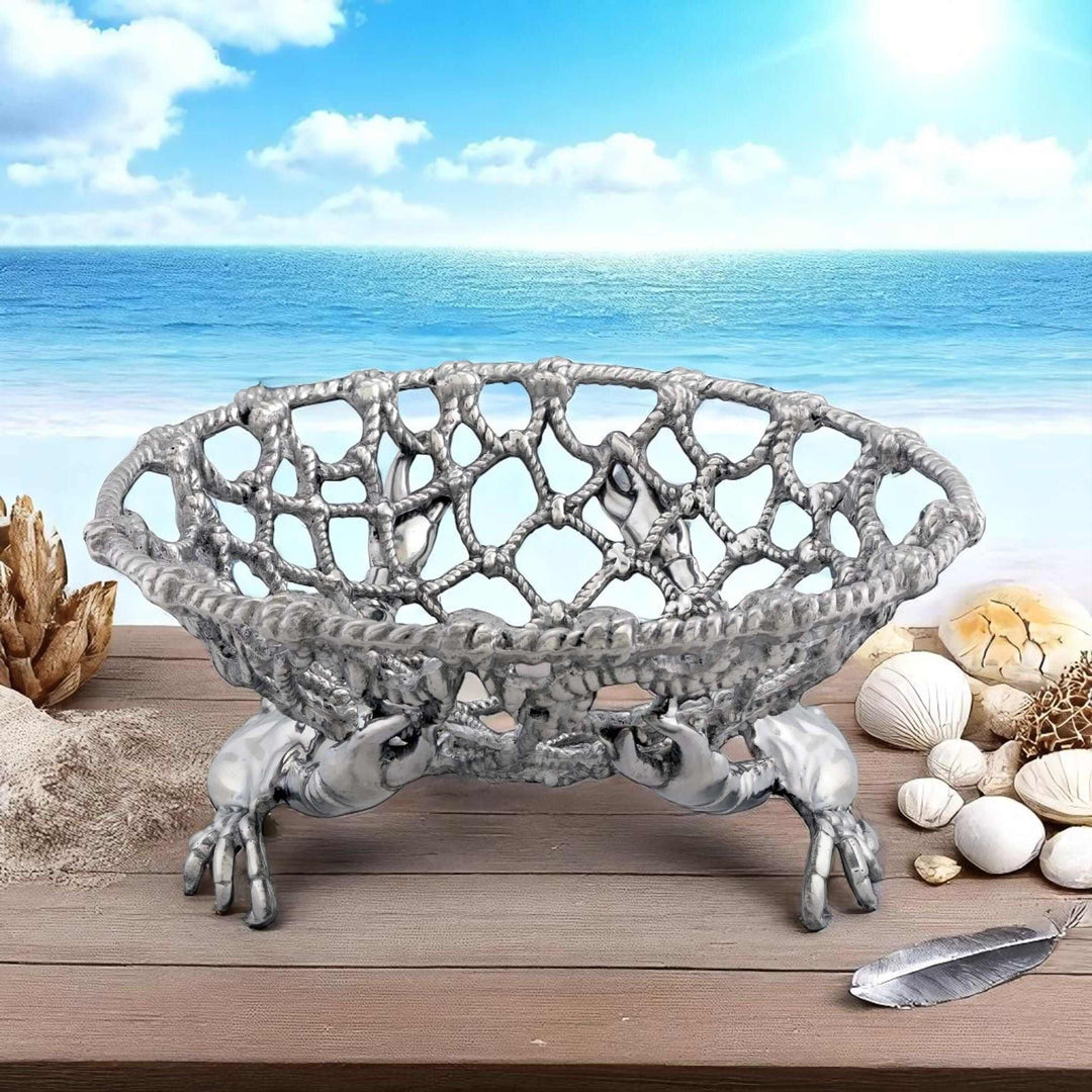 Coastal Crab and Net Fruit Basket displayed on a wooden table with a seaside background, featuring handcrafted aluminum design.