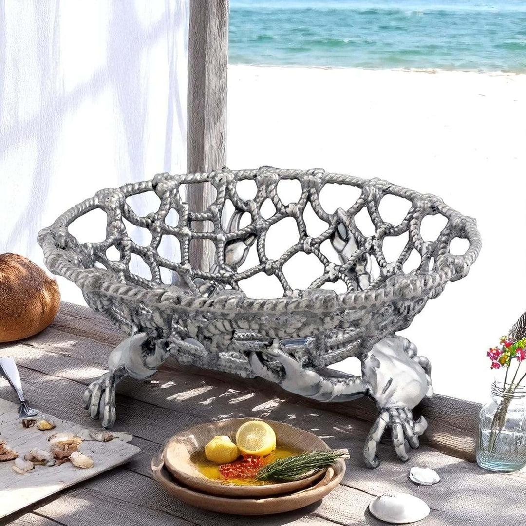 Coastal Crab and Net Fruit Basket on seaside table, handcrafted aluminum design reflecting maritime tradition.