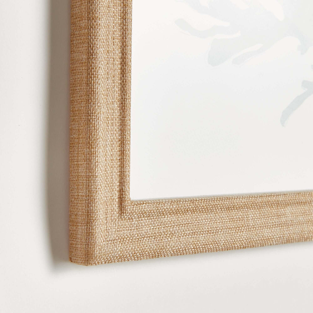 Close-up of a natural wood frame with fabric-wrapped texture, highlighting elegance and coastal decor style.