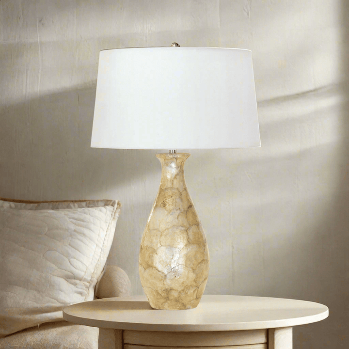 Coastal Pearl Capiz Shell Table Lamp with Linen Shade on elegant side table, illuminating rustic decor.