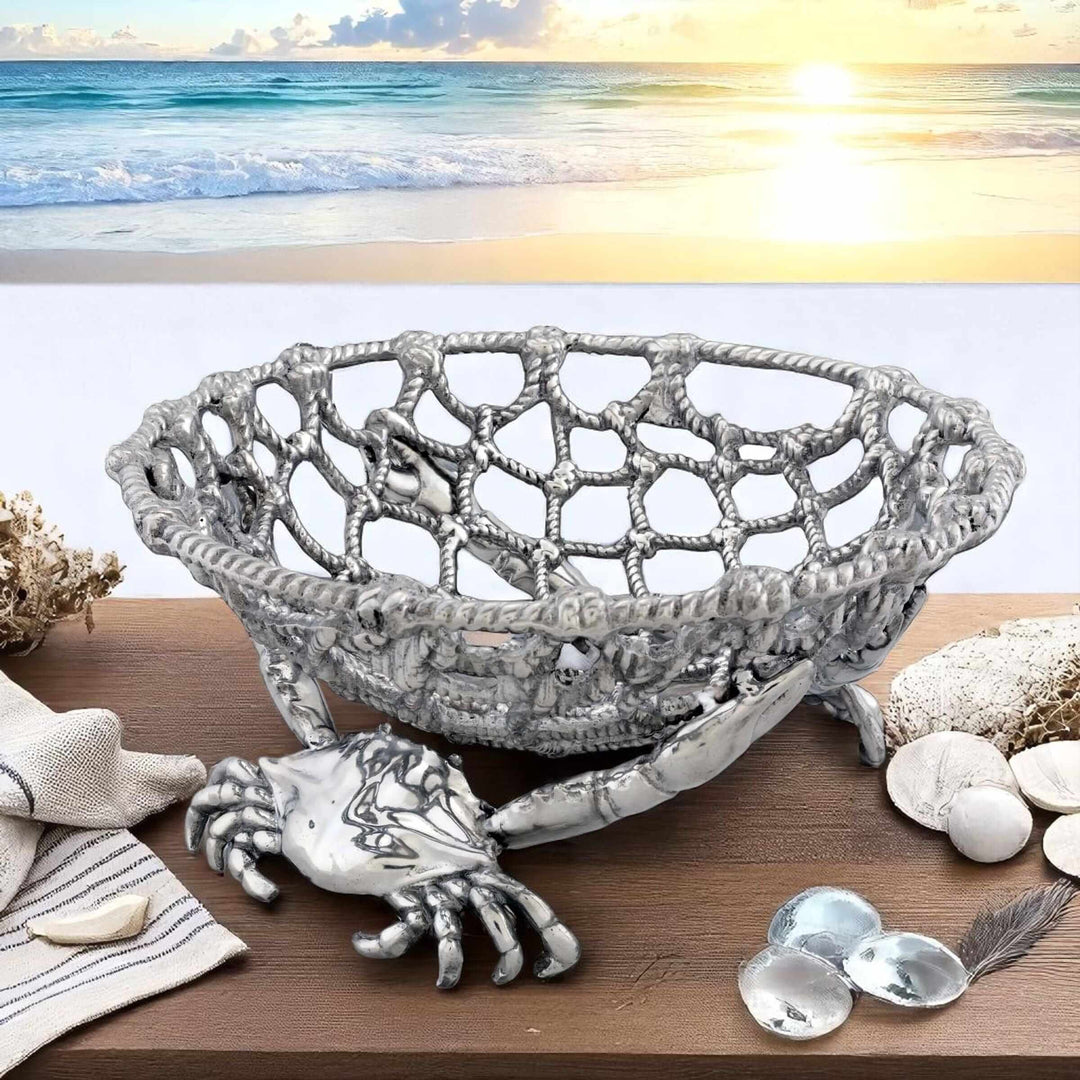 Handcrafted Coastal Crab and Net Fruit Basket with ocean backdrop, made of luminous aluminum, captures seaside elegance.