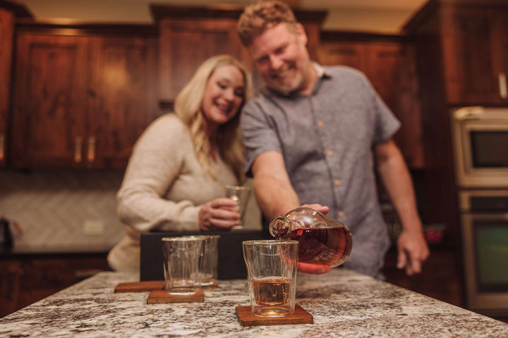 Couple enjoying whiskey from the Old World Whiskey Decanter and Glass Set in Faux Leather Case, adding elegance to a cozy evening.