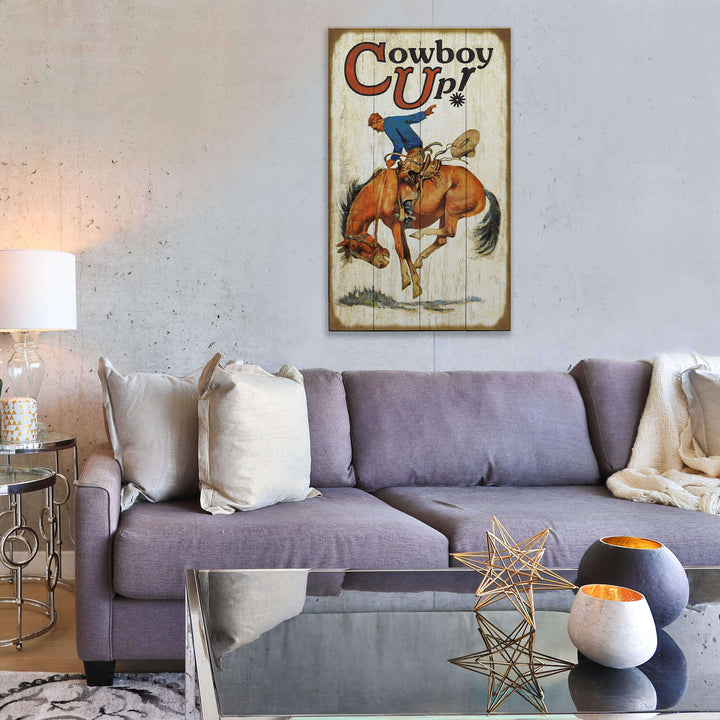 Living room with a gray sofa, decorative pillows, and a 'Cowboy Up!' poster on the wall.