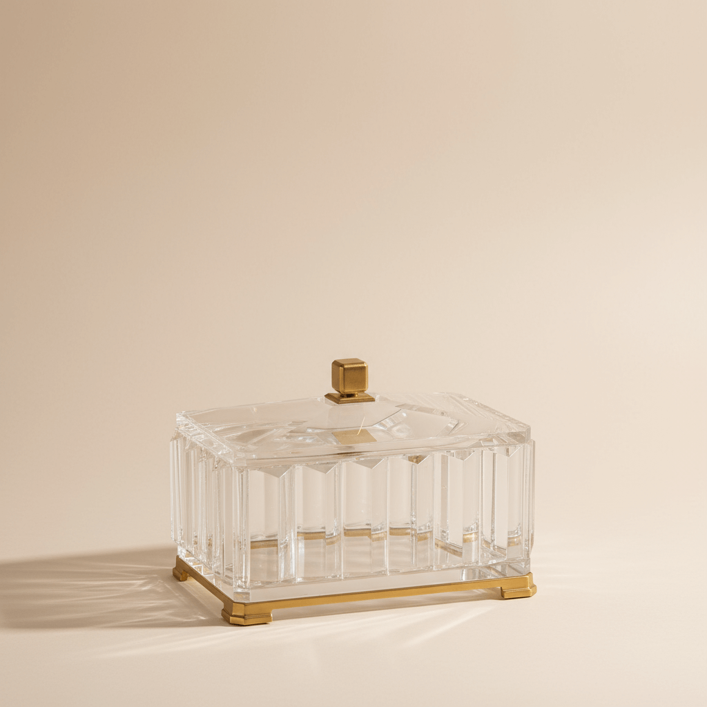 Clear glass box with gold accents on a beige background