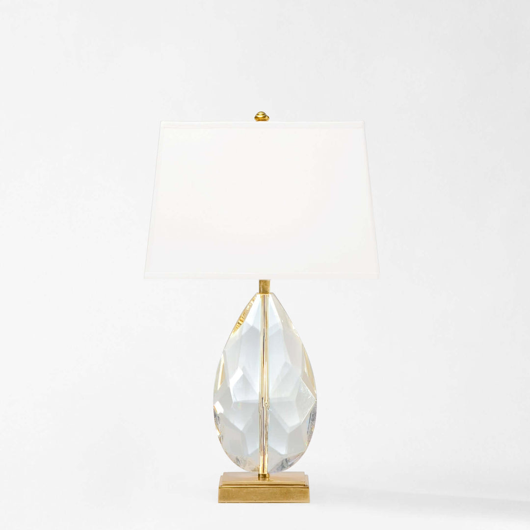 Crystal teardrop table lamp on a gold stand against a white background