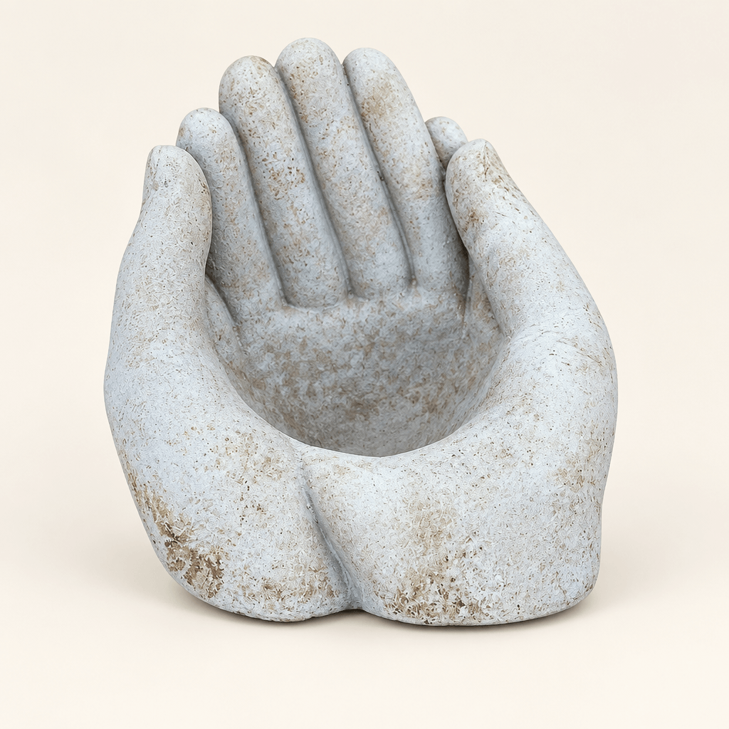 Weathered cement cupped-hands planter on an ivory studio background
