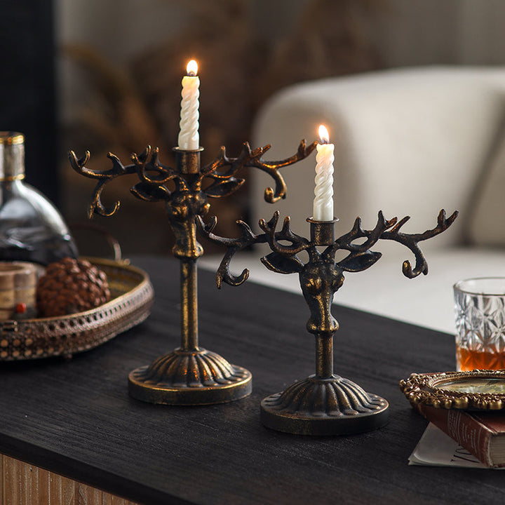 Tall and short Deer Antler Taper Candle Holders glowing on a dark table