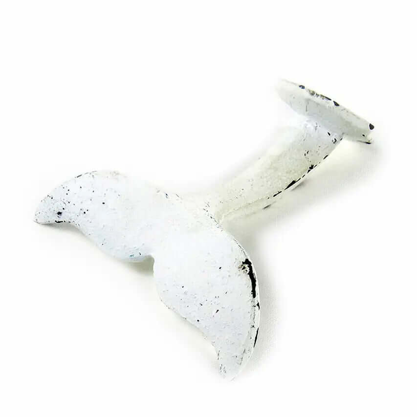 Distressed white cast iron whale tail wall hook shown on white