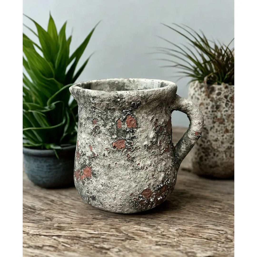Distressed cement floral pitcher pot with curved handle