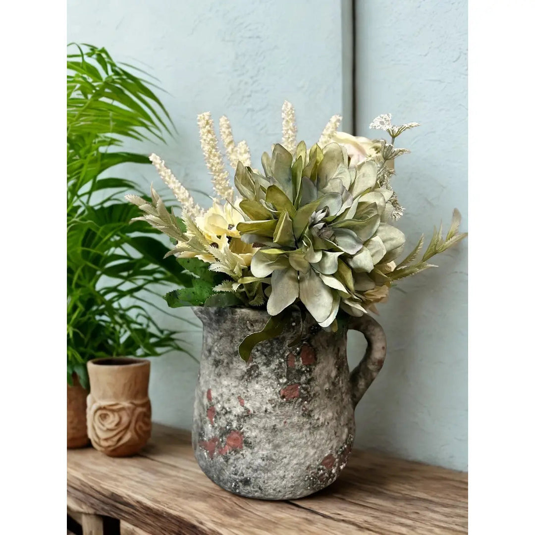 Cement pitcher pot planted with small flowers