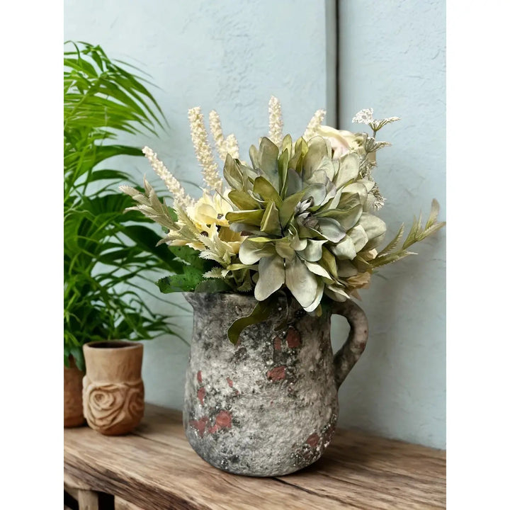 Cement pitcher pot planted with small flowers