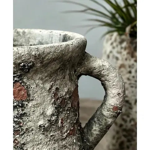 Close view of the distressed cement surface and spout