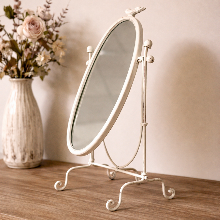 Angled view of the oval tabletop mirror and scrolling feet