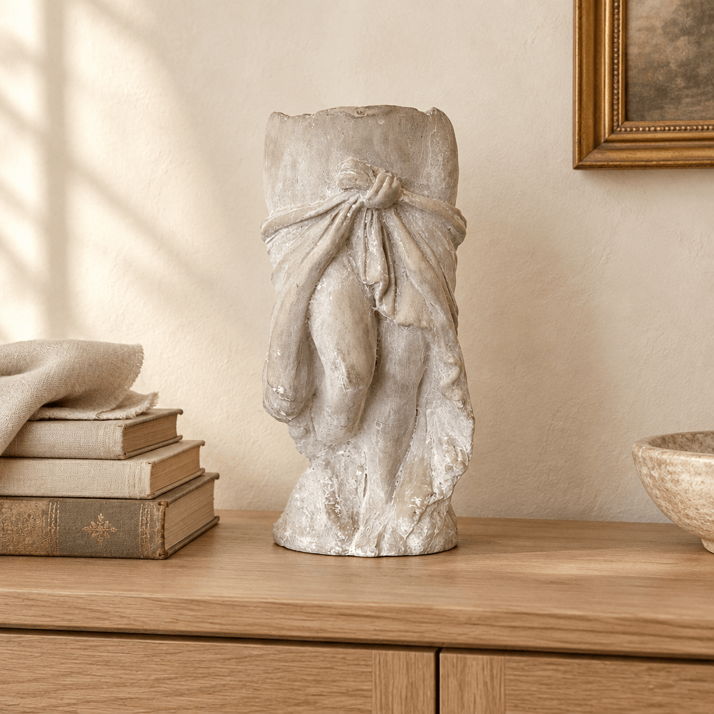 Draped skirt cement planter displayed as a sculptural accent on a light oak sideboard