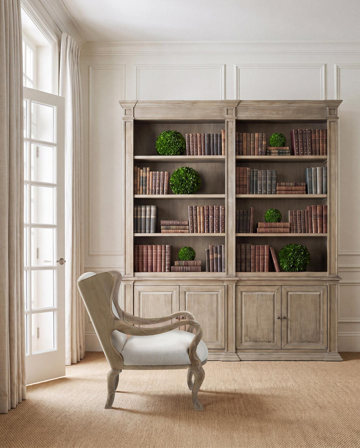 Driftwood ribbon armchair styled beside a large wood bookcase.