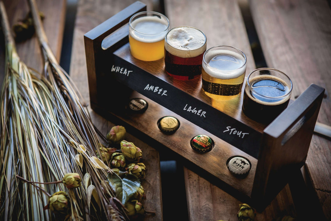 Rustic Craft Beer Flight Tasting Set with acacia wood tray and four glasses for beer sampling on a wooden table.