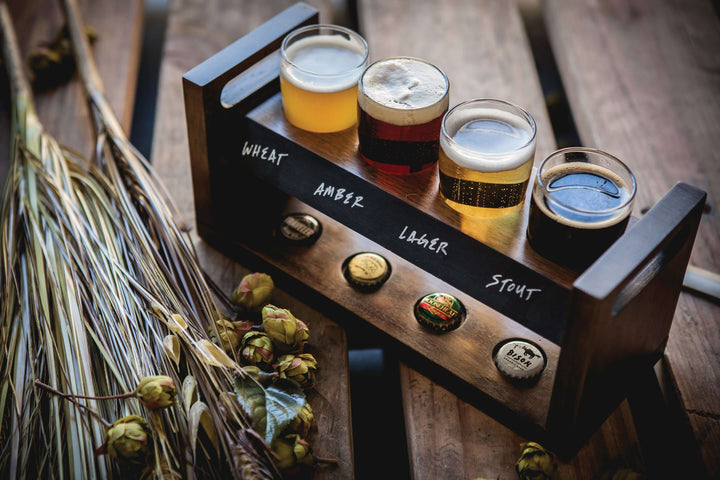Rustic Craft Beer Flight Tasting Set with acacia wood tray and four glasses for beer sampling on a wooden table.