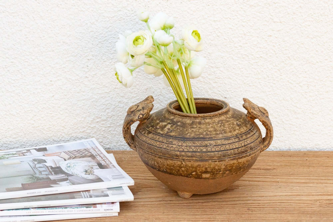 Early Chinese Terracotta Jar with Animal-Form Handles displayed with white flowers, showcasing historical craftsmanship and elegant design.
