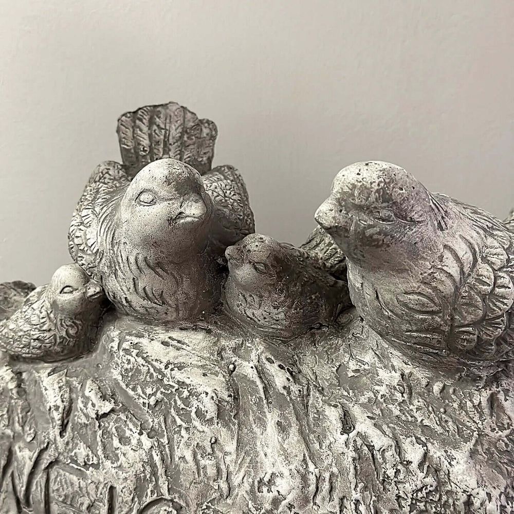 Vintage cement birds welcome sign with four detailed songbirds perched on a weathered stone base, adding charm to gardens or entryways.