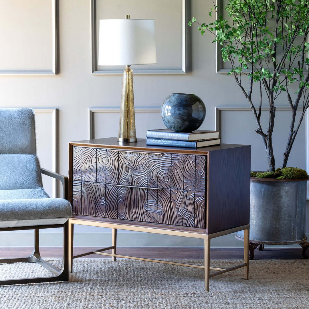 Crackled glass table lamp with white linen shade on wooden sideboard in elegant living room setting.