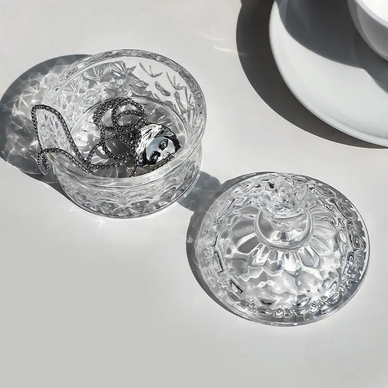 Embossed glass jar holding jewelry in direct sunlight