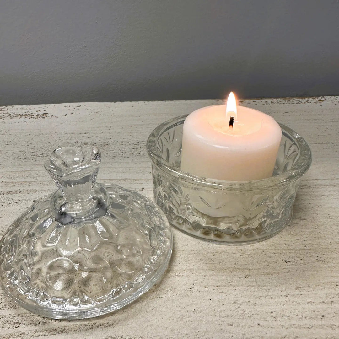 Flower-lidded glass trinket jar used as a small candle holder