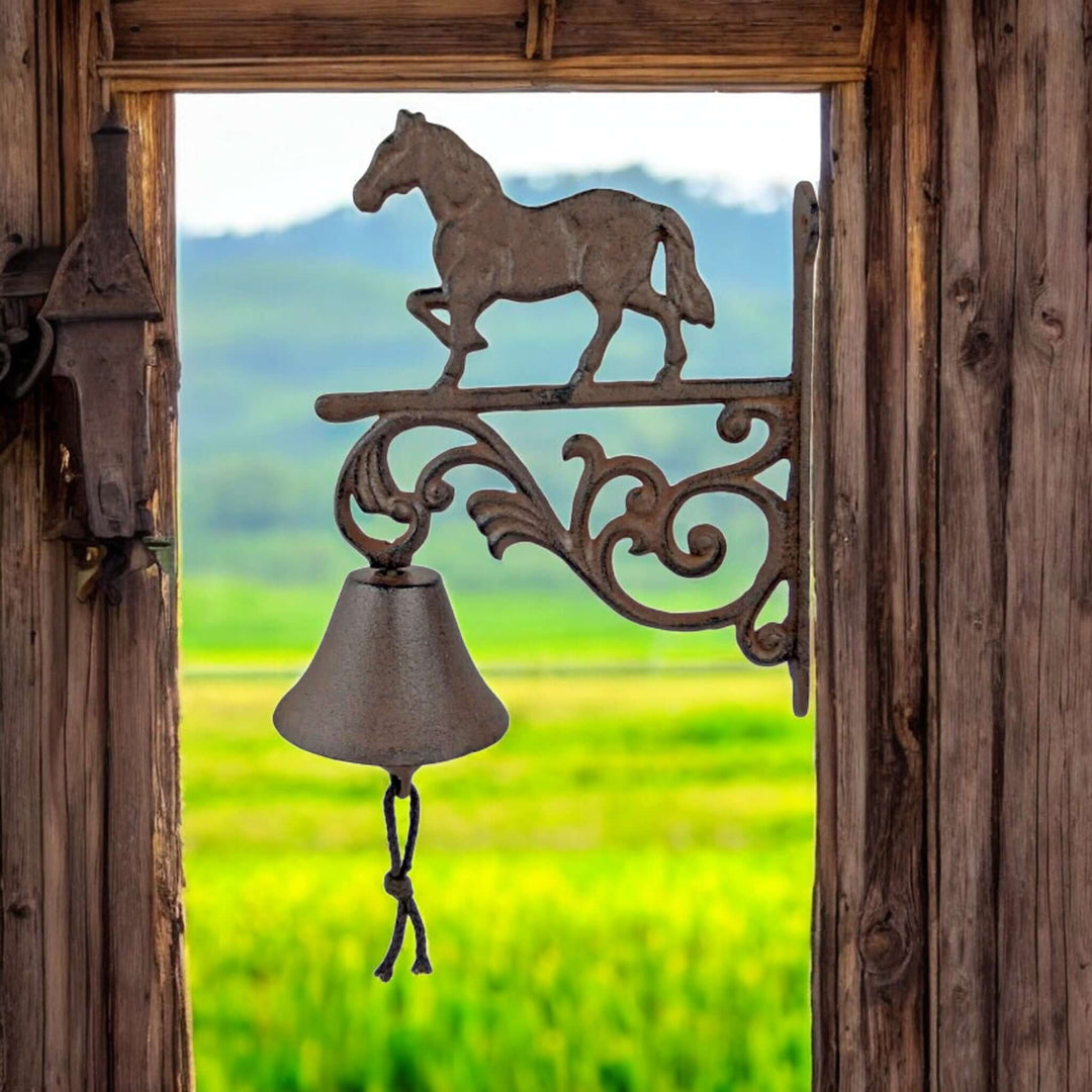 Equestrian Cast Iron Horse Bell mounted on wooden frame with scenic countryside view in the background