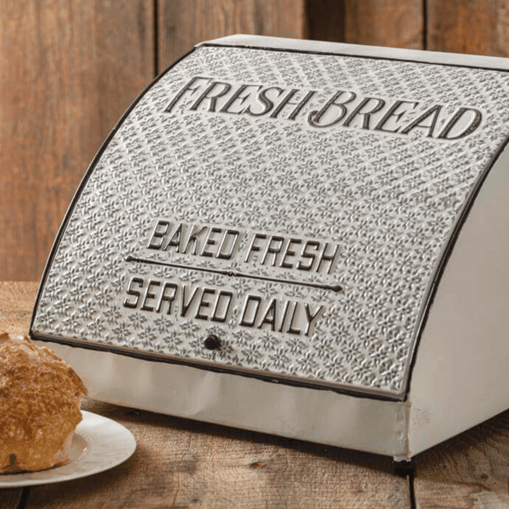 Vintage metal farmhouse bread box with decorative lettering, perfect for storing bread and baked goods.