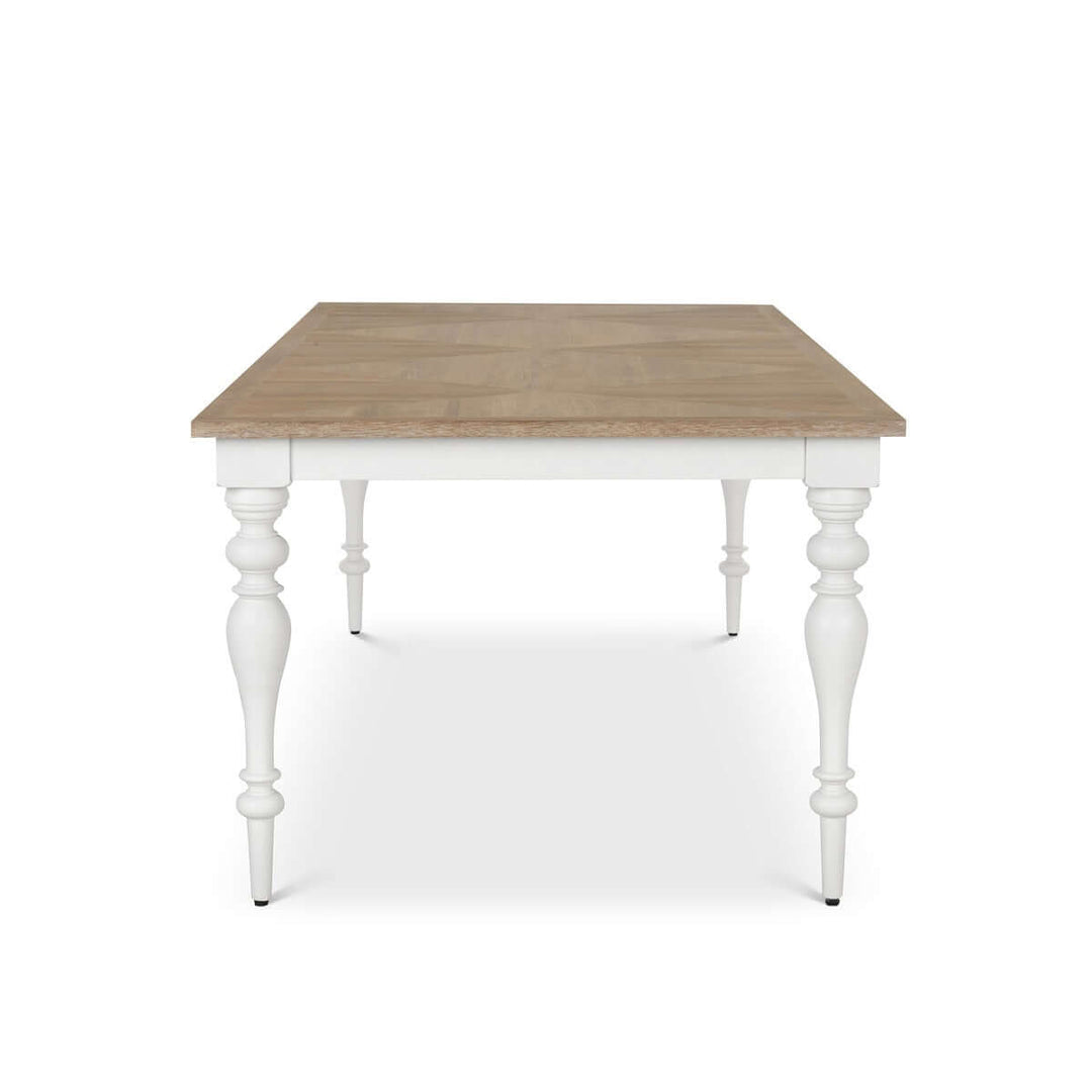 Farmhouse dining table with vintage white turned legs and a richly grained wood tabletop, perfect for countryside gatherings.