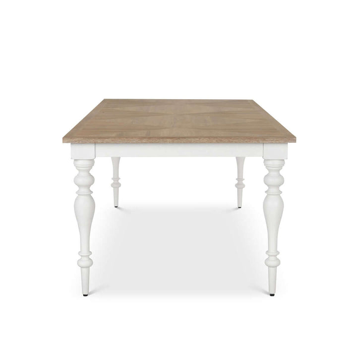 Farmhouse dining table with vintage white turned legs and a richly grained wood tabletop, perfect for countryside gatherings.