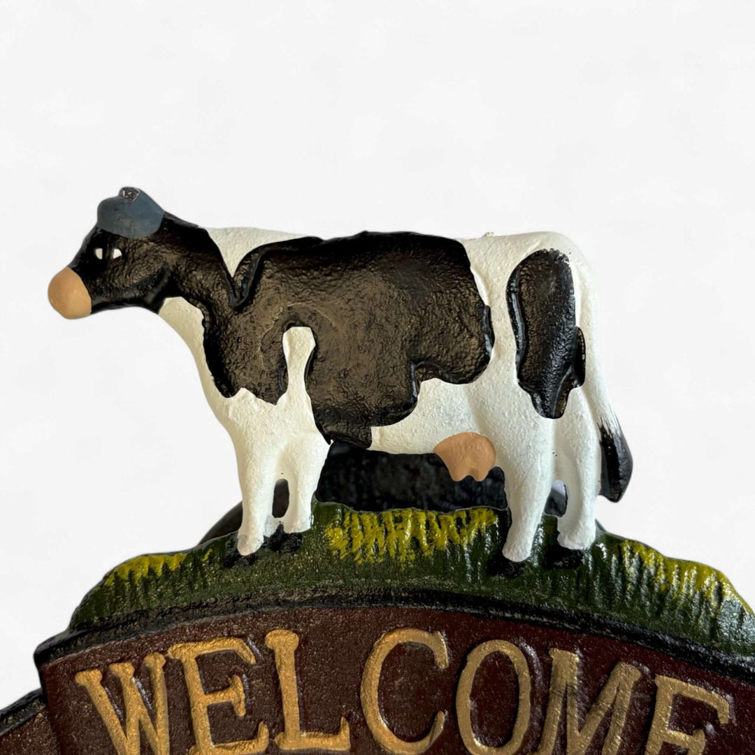 Farmhouse Cast Iron Cow Welcome Sign with Bell featuring a cow design on a rustic background.